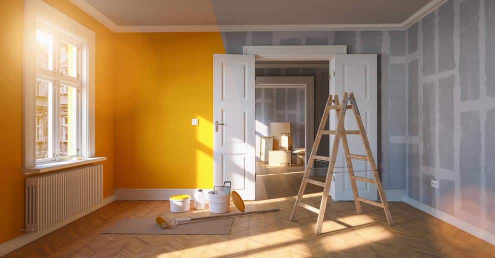 An empty room with yellow walls and a ladder