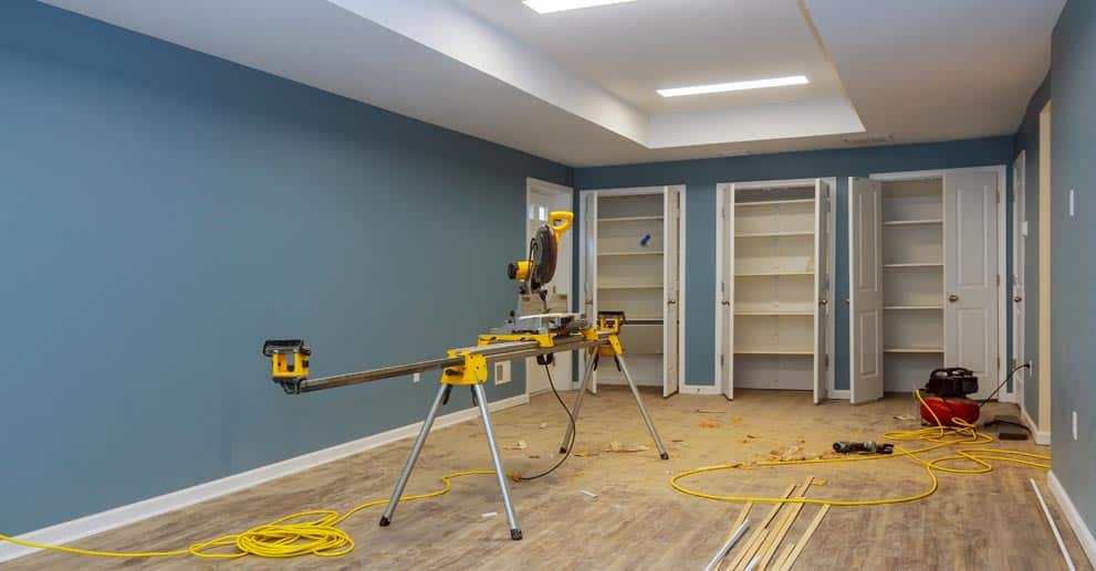 A room being remodeled with wood floors and blue walls